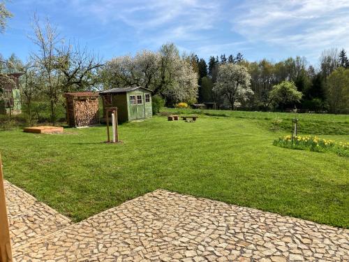 a garden with a smallshed in the middle of a field at Stodola 63 in Pacov