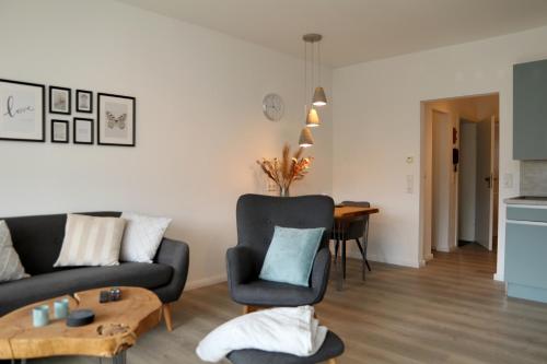 a living room with a couch and a table at Seeblick25 - Apartments - Balkony - WIFI - Great View - New & Modern in Winterberg