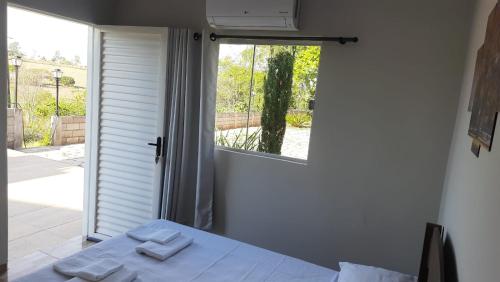 ein Zimmer mit einem Bett und einem Fenster mit Handtüchern darauf in der Unterkunft Pousada Chacara Princesa Isabel in São José da Barra
