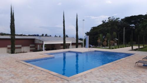 a large blue swimming pool in a courtyard at Pousada Chacara Princesa Isabel in São José da Barra