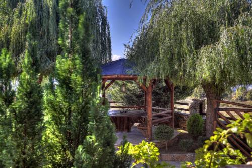 a wooden gazebo with a picnic table and trees at Petrina House in Angistron