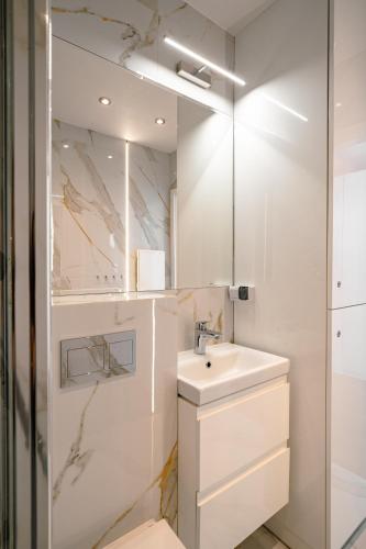 a white bathroom with a sink and a mirror at VENTUNO in Stegna