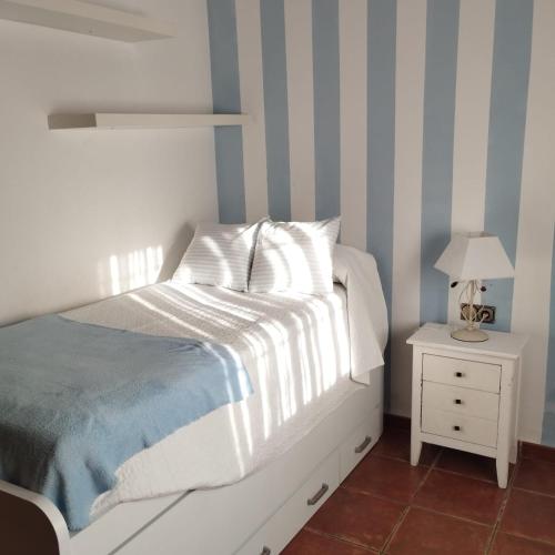 een slaapkamer met een bed en een nachtkastje met een lamp bij Casa Ayala in Ronda