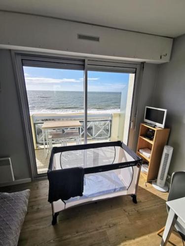 une chambre avec un lit avec vue sur l'océan dans l'établissement Sur la plage de Bonne Source les pieds dans l'eau, à Pornichet