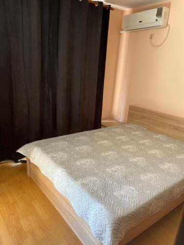 a bed in a room with a black curtain at Частен апартамент Лагуна - Private Two-Bedroom Apartment Laguna in Primorsko