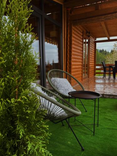 a patio with two chairs and a table on the grass at Casa Mia Resort in Kupres