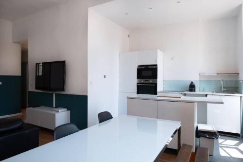 a kitchen with white cabinets and a table and chairs at T2 La Joliette, 13002 Marseille in Marseille