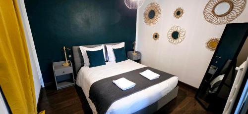 - une chambre dotée d'un lit avec des draps bleus et blancs dans l'établissement Le Kalloé, à Thonon-les-Bains
