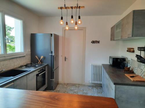 une cuisine avec un réfrigérateur en acier inoxydable et un évier dans l'établissement Villa La Faute-sur-Mer, à La Faute-sur-Mer