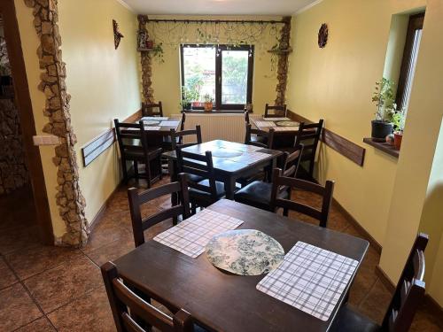 um restaurante com mesas e cadeiras de madeira e uma janela em Casa Adelmar em Tulcea