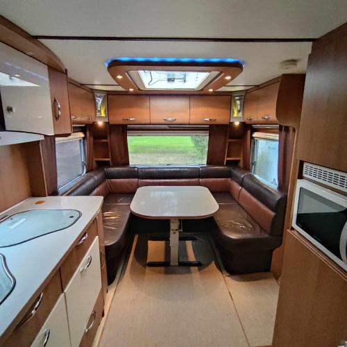 une petite pièce avec une table à l'arrière d'un train dans l'établissement Chambres insolites caravanes -Cheverny -Chambord -Zoo Beauval-Chenonceau, à Fougères-sur-Bièvre