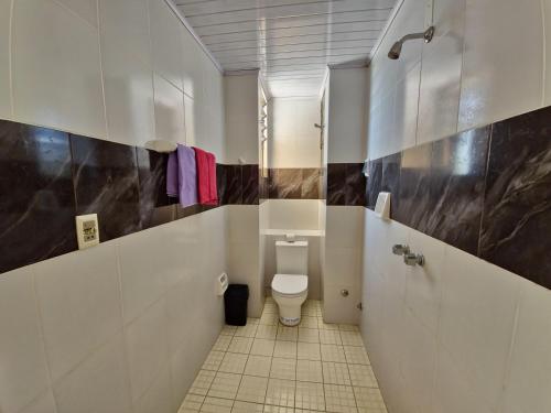 une salle de bain avec des toilettes blanches dans une chambre dans l'établissement HOSTAL GALO, à Tarija