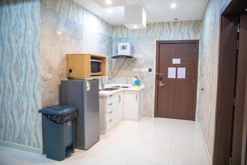 a small kitchen with a refrigerator and a microwave at شقق بيت المدينة للشقق المخدومة in Al Madinah