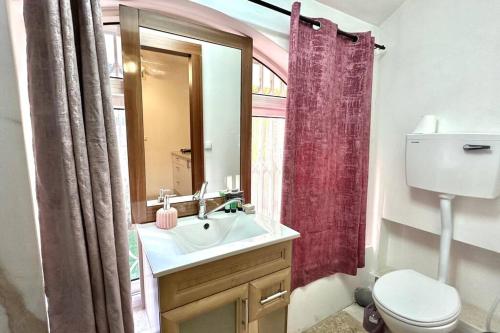 a bathroom with a sink and a toilet and a mirror at Studio in the center with BBQ Patio and parking in Nahariyya