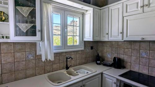 a kitchen with two sinks and a window at Anoi House by the sea Agios Fokas Tinos in Tinos Town