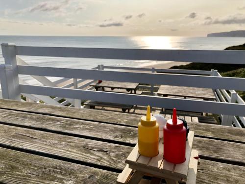 a wooden bench with two ketchup and mustard bottles at The Cosy Retreat in Filey