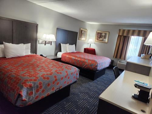 a hotel room with two beds and a desk at Twin Cities Inn, Mounds View in Mounds View