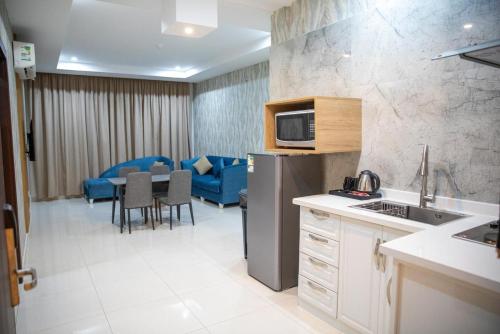 a kitchen and dining room with a table and a refrigerator at شقق بيت المدينة للشقق المخدومة in Al Madinah
