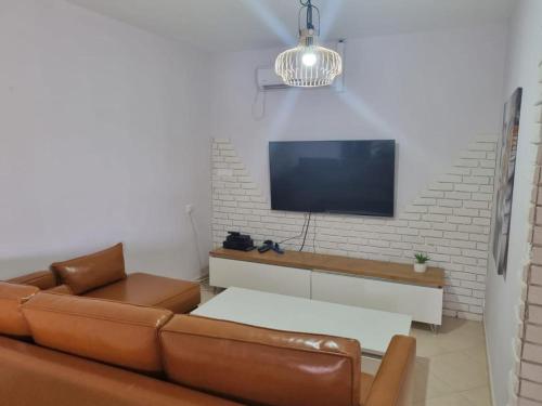 ein Wohnzimmer mit einem Sofa und einem Flachbild-TV in der Unterkunft צימר רמון in Mitzpe Ramon