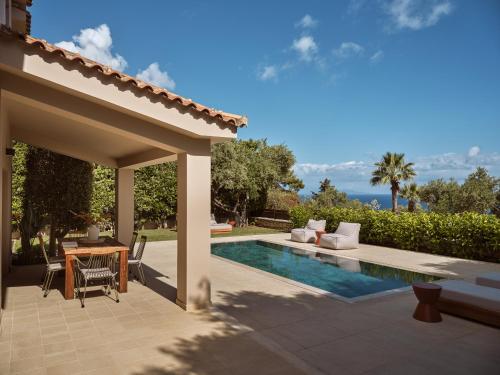 podwórko z basenem, stołem i krzesłami w obiekcie Cielo villas - An Authentic Mediterranean Living w mieście Zakintos