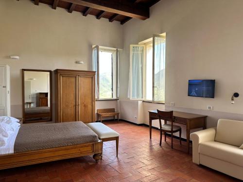 a bedroom with a bed and a table and a couch at Hotel Palazzo Costa in Beverino