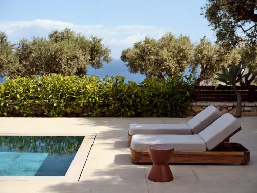 a patio with a white couch and a pool at Cielo villas - An Authentic Mediterranean Living in Zakynthos Town