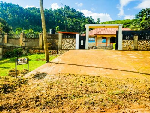 Mianzi Guest House في Kisoro: منزل فيه لافته امام ساحه