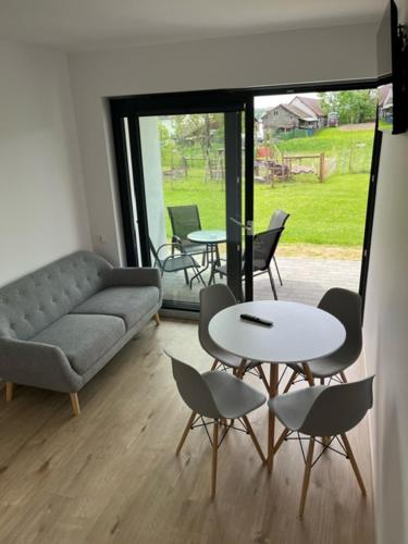 a living room with a couch and a table and chairs at Jula - apartamenty w Kudowie-Zdrój in Kudowa-Zdrój