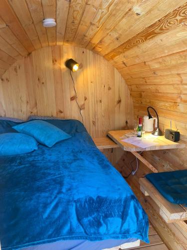 een bed in een houten kamer met een tafel bij Schlaffass Am Brocken - Schierke in Schierke