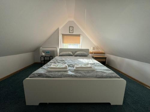 - une chambre mansardée avec un lit blanc dans l'établissement Sunny Home Turawa, à Turawa