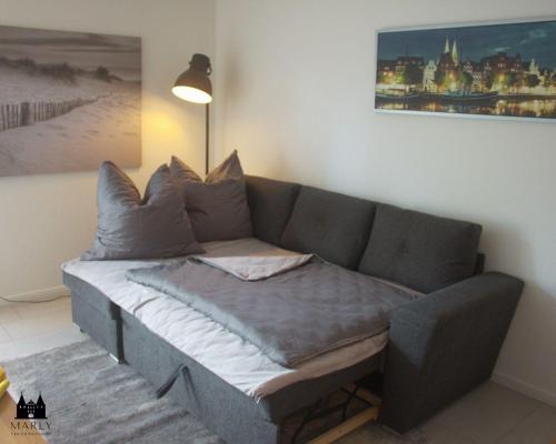 a couch in a living room with a painting on the wall at Ferienwohnung Marly in Lübeck