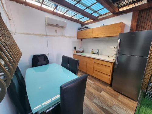 een kleine keuken met een tafel en een koelkast bij מיני צימר רמון in Mitzpe Ramon