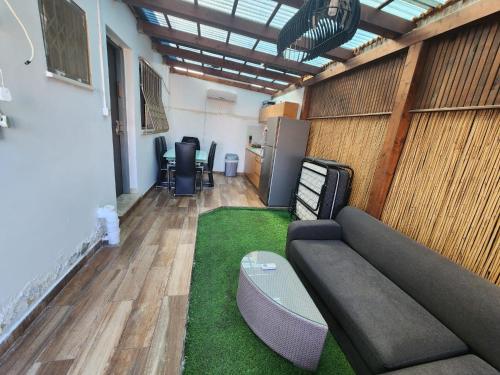 ein Wohnzimmer mit einem Sofa und einem grünen Teppich in der Unterkunft מיני צימר רמון in Mitzpe Ramon