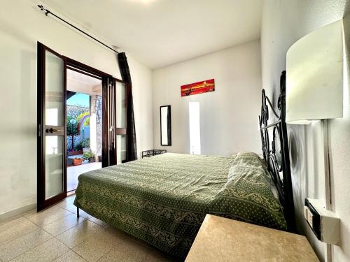 1 dormitorio con 1 cama y puerta que da a un patio en Casa del Sole, en Campofelice di Roccella