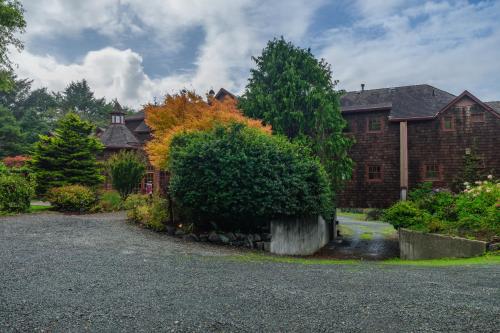 a house with a large bush in front of it at Arch Cape Inn and Retreat in Arch Cape