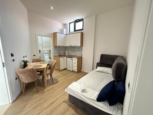 a bedroom with a bed and a table and a kitchen at Arial Trinity Suites in Vlorë