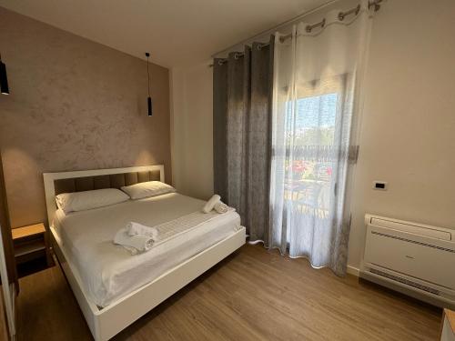 a bedroom with a white bed and a window at Arial Trinity Suites in Vlorë