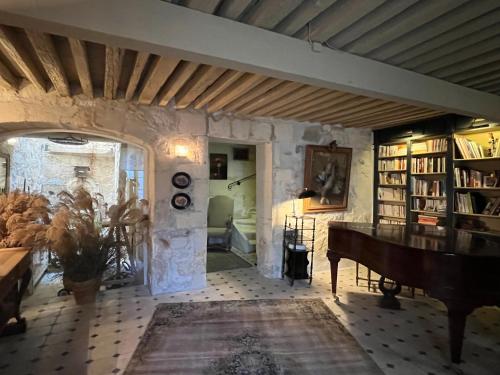 a living room with a piano and a room with books at La Maison de Fabienne in Tarascon