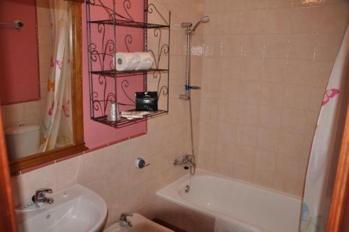 e bagno con lavandino, servizi igienici e vasca. di Casa Rojas a Tarifa
