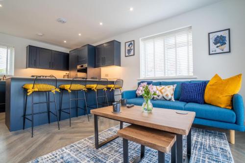 a living room with a blue couch and a table at North Horsham House in Horsham