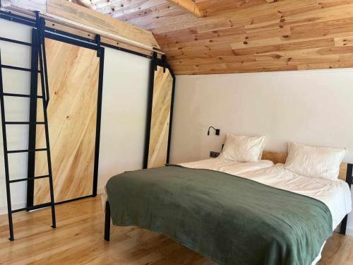 - une chambre avec un lit dans une pièce dotée de plafonds en bois dans l'établissement Bajkowy Domek 2 nad rzeką Liwiec, à Łochów