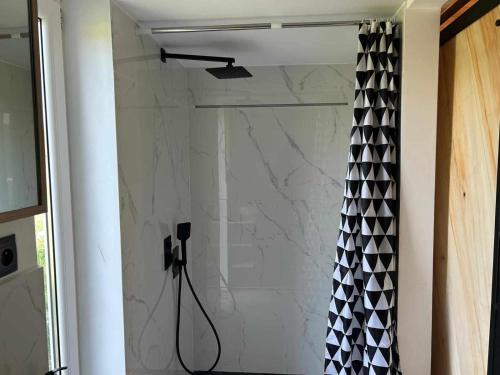 a shower with a black and white shower curtain at Bajkowy Domek 2 nad rzeką Liwiec in Łochów
