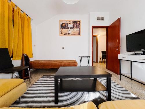- un salon avec une table et une télévision dans l'établissement Apartment with patio and parking, à Nahariya