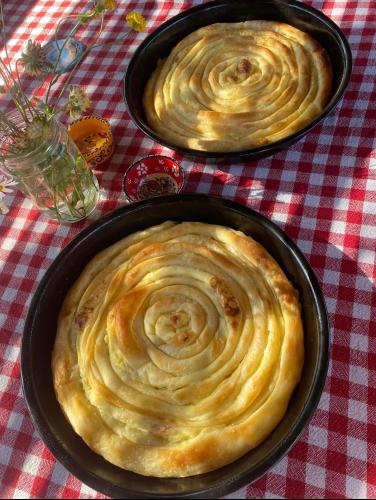 two pans of food sitting on a table at Cottages of Nišići in Sarajevo