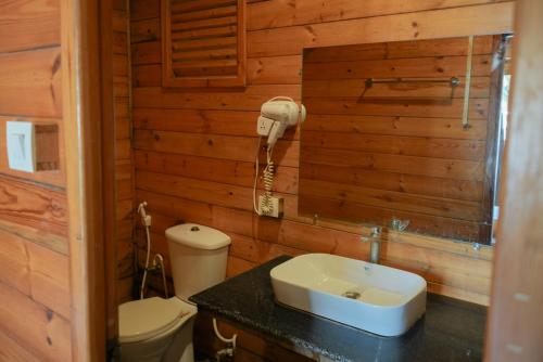 a bathroom with a toilet and a sink and a phone at Seawood beach front resort in Morjim