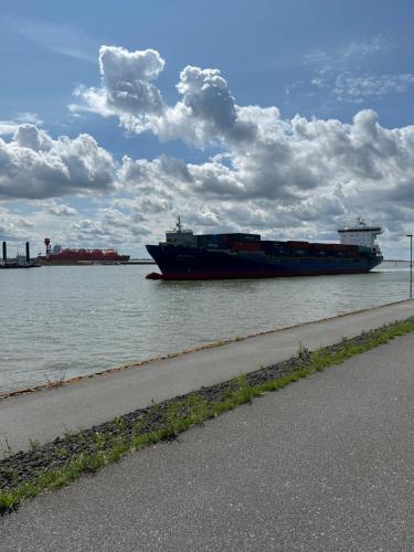 a large boat in the water next to a road at Zimmer Lummerland in Brunsbüttel