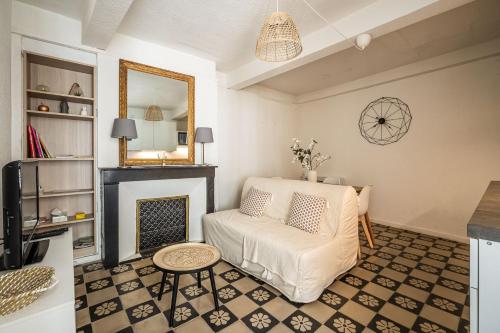 - un salon avec une cheminée et un canapé blanc dans l'établissement Charmant studio Rue Droite, à Narbonne