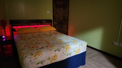 a bedroom with a bed with a floral bedspread at ZionGates in Castries