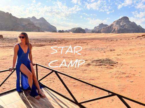 Una donna con un vestito blu in piedi nel deserto di STAR CAMP & WiTH TOR a Wadi Rum