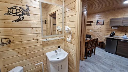 a bathroom in a log cabin with a sink at Domki Sowia Polana in Dąbki